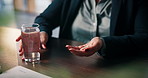Pills, glass of water and hands of woman in home with medicine, prescription and medication. Healthcare, recovery and person with container for vitamins, supplements and drugs for medical symptoms