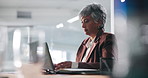 Mature woman, laptop and night at office with typing, review and deadline for project at media agency. Person, journalist and writer with overtime, feedback or editing process for newsletter article