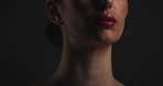 Glow, dermatology and cosmetic with woman in studio on dark background for shadow, art or cosmetology. Beauty, skincare and lighting for serious model in shade for change, transformation or aesthetic