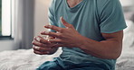 Man, hands or playing with ring in bed for divorce, breakup or marital problems in home. Closeup, male person or doubt with jewelry, regret or stress for commitment, regret or toxic marriage in house