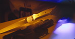 Person, hands and knife with fingerprint for investigation, suspect or murder weapon. Detective, clue or blue light with evidence of serial killer identity or DNA for crime scene or forensic analysis