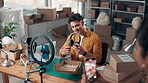 Live streaming. headphones and ecommerce with man in warehouse for dropshipping, product and review. Broadcast, social media promotion and tech supplier with people in factory for distribution