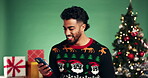 Happy, man and online shopping with smartphone, Christmas and browsing for gift discount and studio. Green background, smile and person with mobile for ecommerce, holiday and search for xmas present
