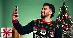 Christmas, man or laughing with selfie in studio for festive memory, funny vlog or holiday season. Influencer, person or happy with photography on green background for xmas celebration or online post