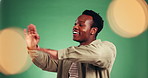 Happy, black man and dancing for fun in studio with energy, groove steps and giveaway winner. Excited, male person and moving with bokeh, celebration and performance of lotto news on green background