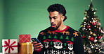 Christmas, surprise and man with phone in studio for fake news, confused or canceled discount. Xmas, shock and person with mobile for online order error or wrong gift notification on green background
