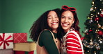 Women, hug and face in Christmas studio with friends, holiday and festive cheer for bonding. Laughing, portrait and embrace by tree for xmas celebration, presents or decoration on green background