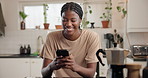 Happy, black woman and typing with phone in kitchen for social media, chatting or texting in home. Female person, user and smile with mobile smartphone for messag app, communication or online network