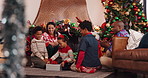 Family, children and gift for Christmas, festive celebration or holiday tradition in living room. Smile, parents and kids with present, excited and surprise for bonding and xmas season in home