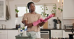 Black woman, housekeeping and kitchen with cleaning supplies for hygiene or disinfection in home. Female person, cleaner or maid getting ready with gloves or bucket of detergent for chores in house