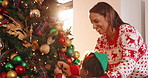 Mom, son and tree with decoration for Christmas, festive celebration or holiday tradition. Smile, woman and child with ornaments, help and flare for family bonding and prepare xmas season in home