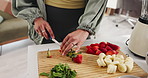 Hands, cutting strawberries and blender in kitchen for smoothie, nutrition or wellness at home. Person, fruit and meal prep for liquid diet, drink or milkshake with organic ingredients for gut health