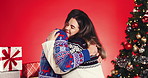 Christmas, hug and love with couple in studio together for bonding and gift or present. Box, celebration or smile with man and woman embracing on red background for festive tradition or holidays