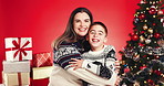 Christmas, love and face of mother and son in studio for holiday season, smile and bonding. Festive celebration, hug and December break with woman and child on red background for family and support