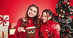 Christmas, sparkler and face of sisters in studio for love, holiday season and happiness. Family bonding, festive celebration and smile with children on red background for December vacation and hug