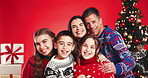 Christmas, face and happy family with kids for holiday, care and love on red studio background. Xmas, mother and father with children, siblings laugh and parents with portrait for festive celebration