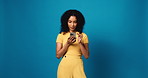 Woman, phone and smile with texting in studio, notification and chat with online dating on blue background. Girl, smartphone and mockup space with contact, app or happy with scroll on social media