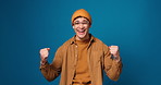 Face, smile and man with wow, congratulations and excited on blue background in studio. Portrait, happy Gen z person and OMG for victory announcement with support, achievement and fist pump on space