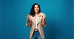 Excited woman, face and winning with phone in studio for good news or bonus on a blue background. Portrait, happy or female person with fist pump on mobile smartphone for app success on mockup space