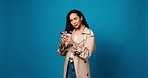 Woman, phone and annoyed in studio with scam, phishing and reading post on blue background. Gen Z person, smartphone and doubt with fake news, gossip and confused on social media with glitch or spam