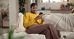 Black woman, living room and laugh with phone, texting and social media for funny meme on home sofa. African person, couch and mobile app with smile, online dating or message in apartment lounge