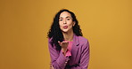 Happy, face and woman blowing kiss in studio for flirting, gratitude or friendly gesture. Smile, love and portrait of female person from Brazil with romantic, kind or cute signal by yellow background