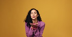 Happy, face and woman blowing kiss in studio for flirting, seductive or alluring gesture. Smile, love and portrait of female person from Brazil with romantic, kind or cute signal by yellow background