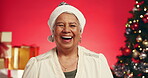Laughing, Christmas and face of old woman in studio for holiday season, retirement and smile. Festive celebration, xmas vacation and December break with elderly person on red background for joke