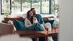 Hug, couple and watching tv with laughing on sofa for comedy movie, bonding and streaming service. Relax, people and happy in home with film subscription, weekend break and funny show entertainment