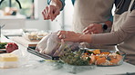 Chicken, hands and stuffing with couple in kitchen of home together for roast dinner or salad recipe. Cooking, food and vegetables with people in apartment for diet, meal preparation or nutrition