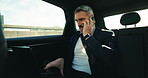 Businessman, private driver and talking with phone call in car for business trip or commute in city. Mature man, travel and working in passenger vehicle with mobile smartphone or laptop for commute