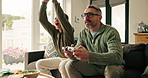 Father, boy and celebration on sofa with video game controller, challenge and happy at family home. People, dad and child with smile, laugh and winner with competition, bonding or love in living room