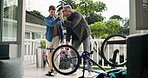 Bicycle, high five or pump with father and son on patio of home for hobby or maintenance. Bike tyre, repair or wheel with boy child and single parent man outdoor in backyard of apartment for success