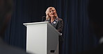 Woman, speech and stage for election with democracy for campaign, low angle or mic at podium for political party. Mature person, talk and politician with conference, crowd and call to action for vote