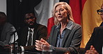 Politics, group and woman with speech at conference for delegation, committee decision or feedback. People, global forum and politician panel with discussion for government initiative and legislation