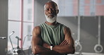 Mature, black man or face with confidence in fitness gym for workout, exercise or wellness. Portrait, male person or serious personal trainer with arms crossed for physical training in health club