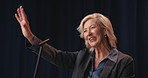 Greeting, mature woman and politician on a stage for election, democracy or political campaign. Speech, microphone and female speaker at conference, meeting or seminar for vote for activism.