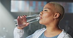 Drinking water, exercise and woman in gym, wellness and hydration with break, fitness and fatigue. Tired, healthy facility and person with liquid in bottle, thirsty and  electrolytes with detox