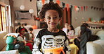 Boy, face and halloween party with basket for candy collection with smile, suit or holiday in home. Child, skeleton costume and happy with sweets container, portrait and trick or treat event at house