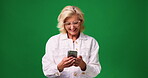 Studio, laughing and woman with smartphone, texting and communication with contact on social media. Read, funny message and mature person with mobile, green background and browsing with tech or space