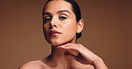 Woman, face and makeup with beauty in studio for cosmetics or cosmetology on a brown background. Portrait, female person or model with skin glow, shine or tone for facial treatment on mockup space