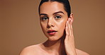 Beauty, touch and face of woman in studio for skincare, facial treatment and dermatology. Spa aesthetic, space and portrait of person with for natural glow, grooming and wellness on brown background