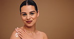Body care, lotion and face of woman in studio with hydration, wellness and cosmetic routine. Happy, mockup space and portrait of person from Portugal with creme for smooth skin by brown background.