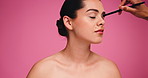 Hands, makeup artist and woman in studio with beauty, eyeshadow or cosmetics routine. Mockup space, brush and female person with facial cosmetology with beautician for grooming by pink background.