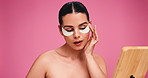Eye patches, mirror and woman in studio, beauty and dermatology on pink background. Mockup space, reflection and person with healthy skin, aesthetic and wellness with shine, confidence and glow