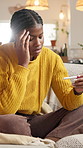 Upset, pregnancy test and black woman on sofa in home with stress for negative result with bad news. Anxiety, unhappy and African female person with pregnant kit for ivf fail in living room at house.
