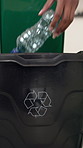 Hands, person and bottle in recycle bin to reuse material, accountability and waste management. Woman, litter and cleaning trash for sustainable disposal, plastic garbage and stop pollution at house