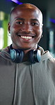 Happy, fitness and face of man in gym with headphones, confidence and workout for muscle development. Exercise, tech and African bodybuilder in health club for strength training, dedication and smile
