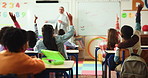 Teacher, students and classroom with hands raised for question, lession or engagement in school. Children, educator or group of learners with answer for youth development or interaction in elementary