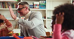 High five, education and man in classroom, students and support with knowledge, growth and learning. Teacher, group and kids in school, achievement and child development with success and motivation